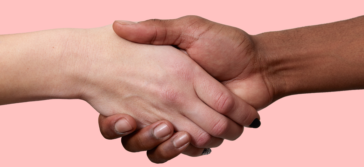 Photo of two shaking hands on a pink background