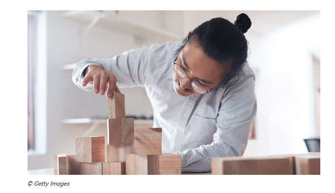 A person stacking wooden blocks