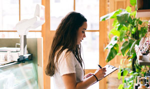 Photo of person writing using a clipboard